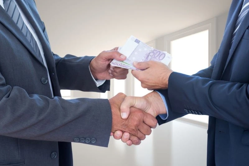 Dwoje mężczyzn podaje sobie rękę zatwierdzając wzięcie pożyczki z gwarantem.